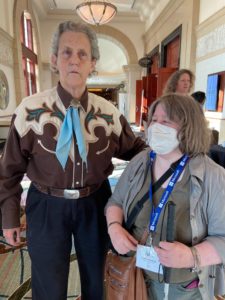 Carin in a mask next to Temple Grandin